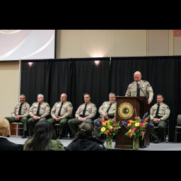 Sheriff Todd Rowell speaks at the Mesa County Sheriff's Office award ceremony with members of the Admin Staff behind him on stage.