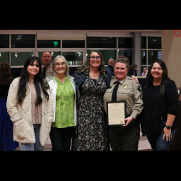 Sergeant C Montez poses with Bobby Gross, Mesa County Clerk and Recorder, and her team.