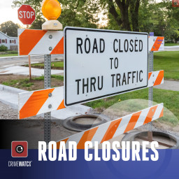 Construction signs at an intersection warning of a road closure.