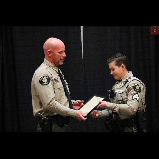 Sergeant Amanda Simon accepts an award from Sheriff Todd Rowell.