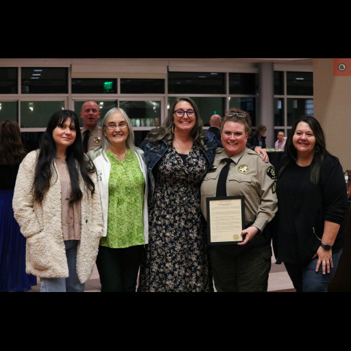 Sergeant C Montez poses with Bobby Gross, Mesa County Clerk and Recorder, and her team.