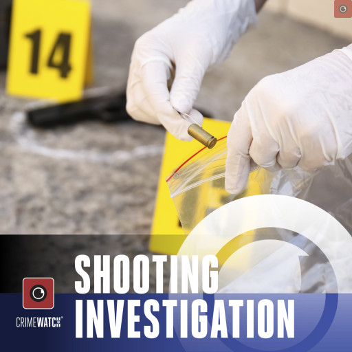 A detective placing a spent shell casing in an evidence bag.