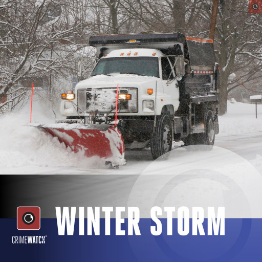 A large plow clearing a snow covered road.
